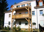 gro&szlig;er Holzbalkon an Mehrfamilienhaus in der Oberlausitz